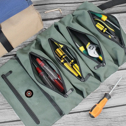 Roll-up tool bag with multiple zippered pockets filled with screwdrivers and pliers on wood surface