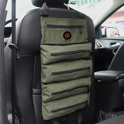 Olive green car seat organizer with multiple zippered pockets hanging on a headrest